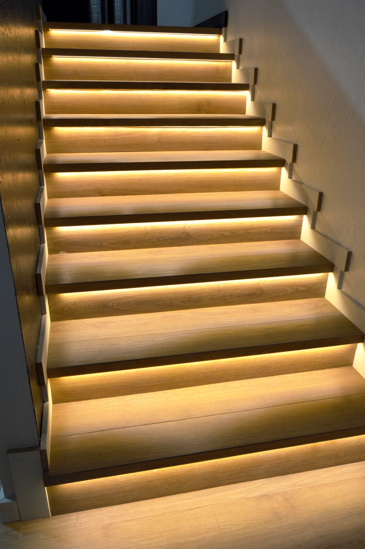 Backlit white oak stair run with warm LED under-tread lighting