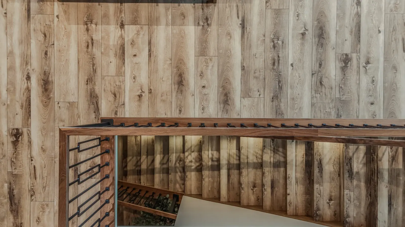 Overhead view of a lit stair run wrapped in plank material