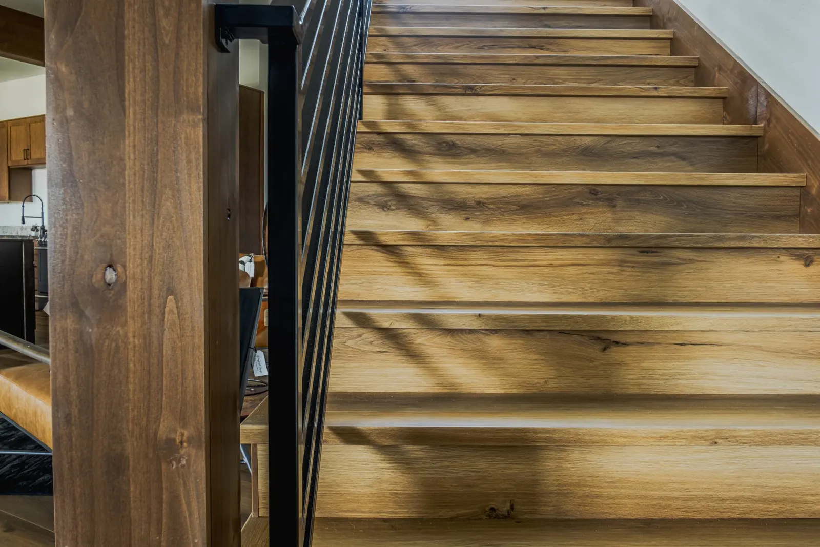 Hickory-toned stair treads with sunlight raking across the run