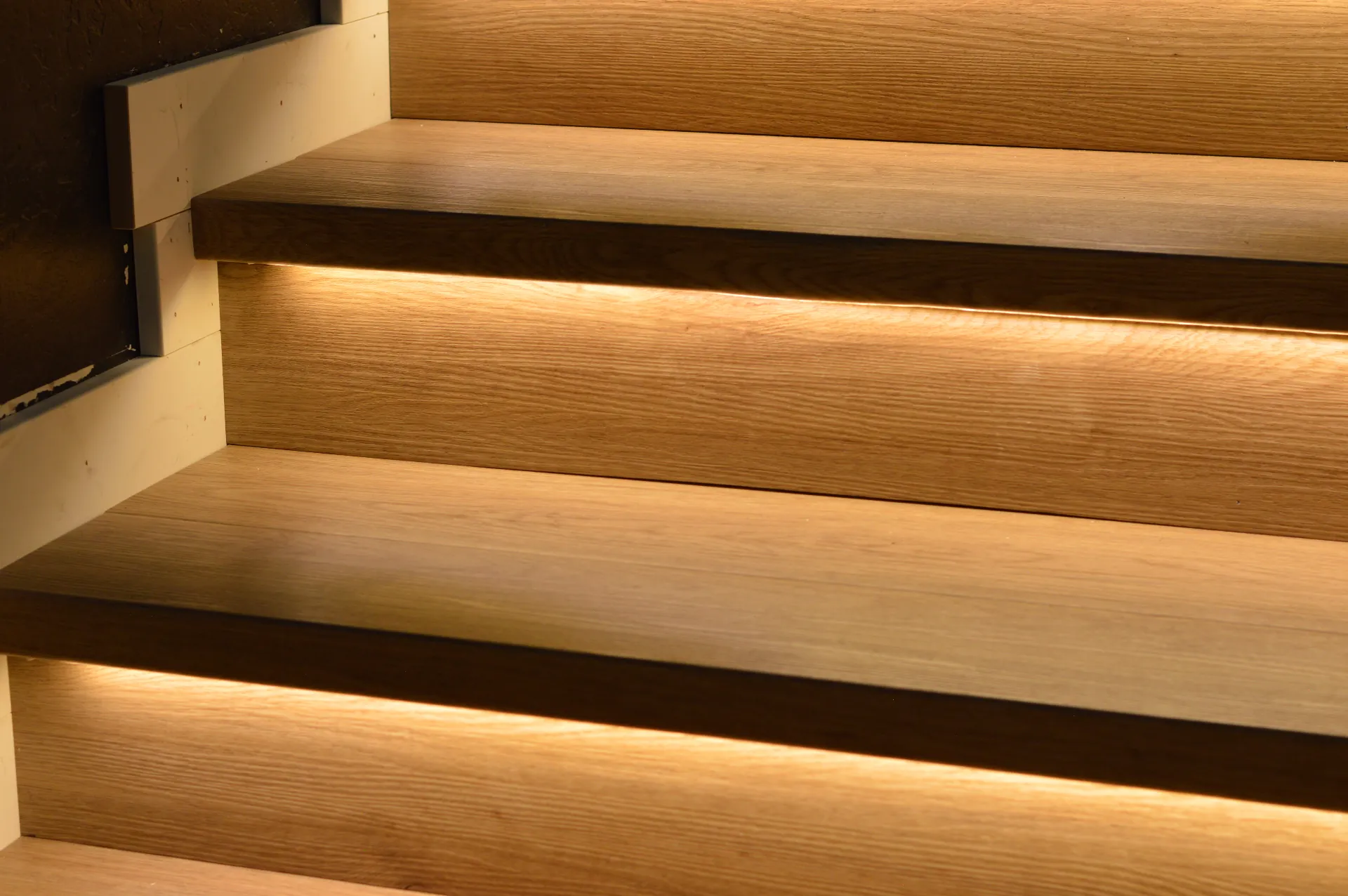 Backlit white oak stair treads with warm under-tread lighting